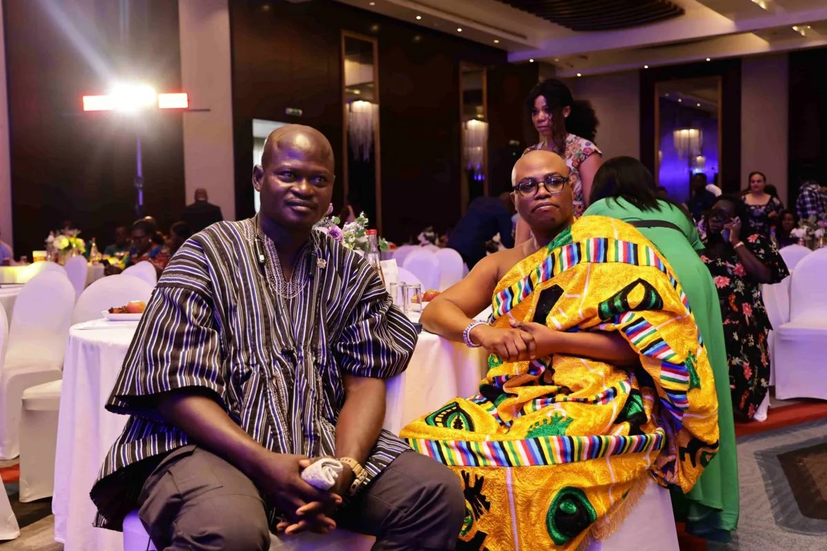 Two guests in traditional attire seated at the awards dinner