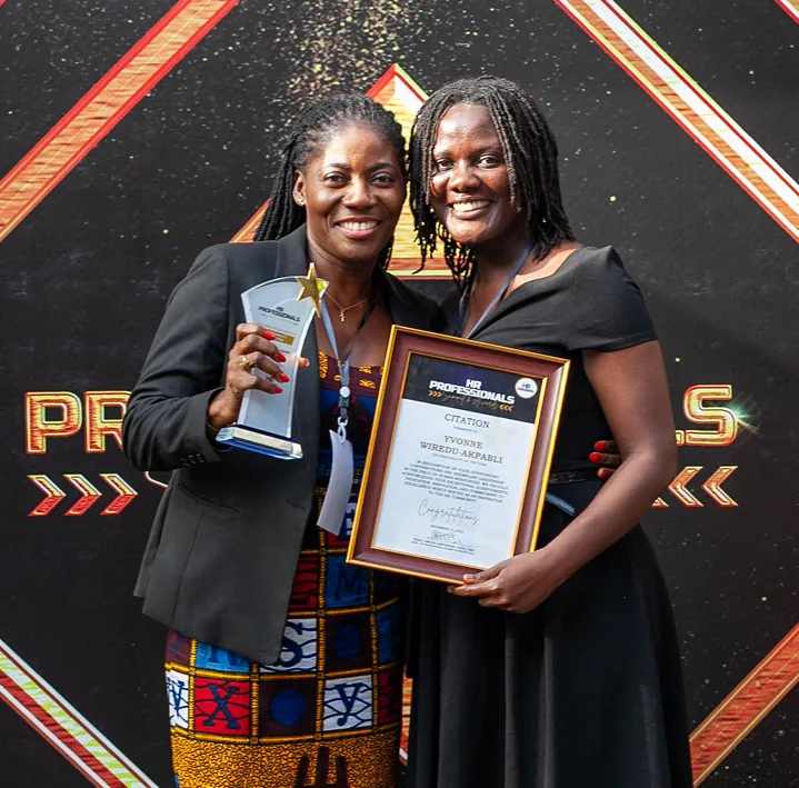 Two awardees holding their trophy and certificate